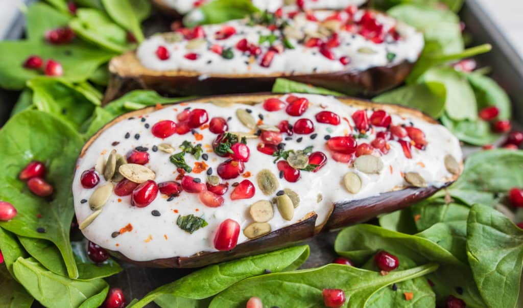 Spicy roasted aubergine recipe bursting with flavours and colours served with creamy yoghurt dressing, pomegranate and sunflower seeds. Vegan & gluten free.