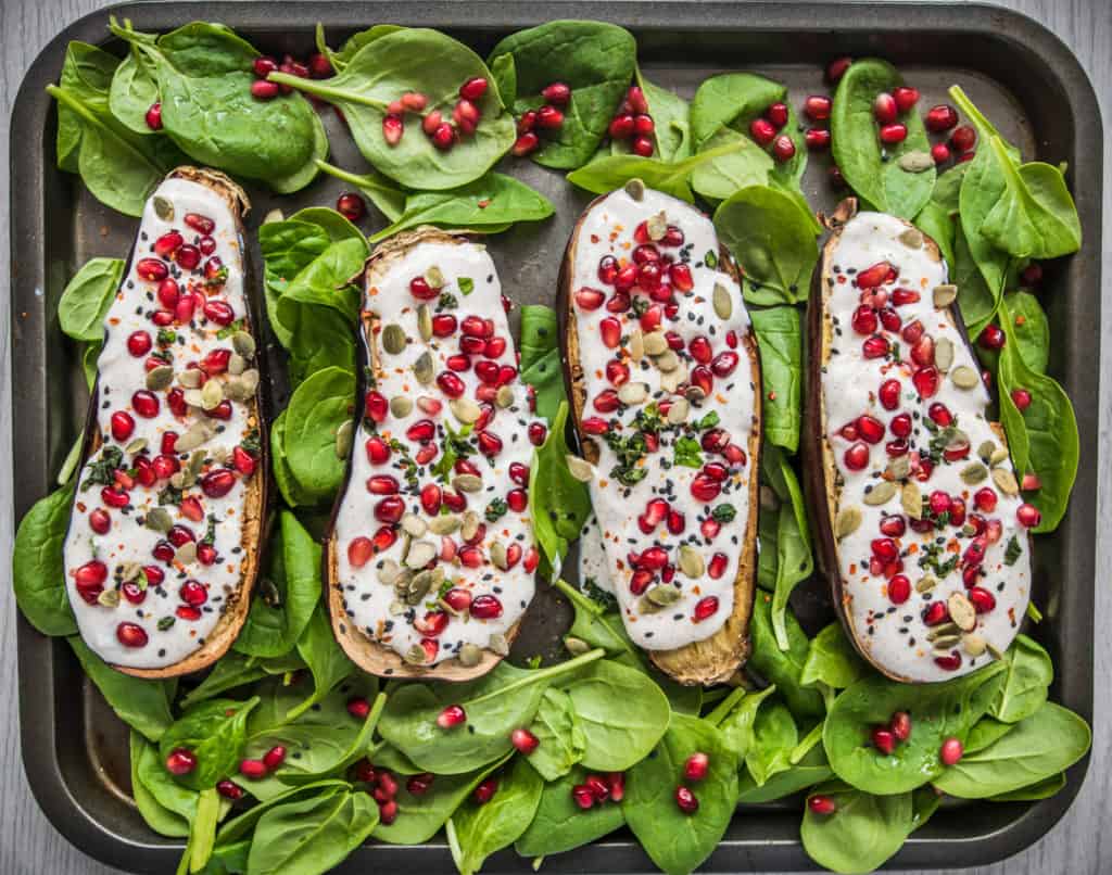 Spicy roasted aubergine recipe bursting with flavours and colours served with creamy yoghurt dressing, pomegranate and sunflower seeds. Vegan & gluten free.