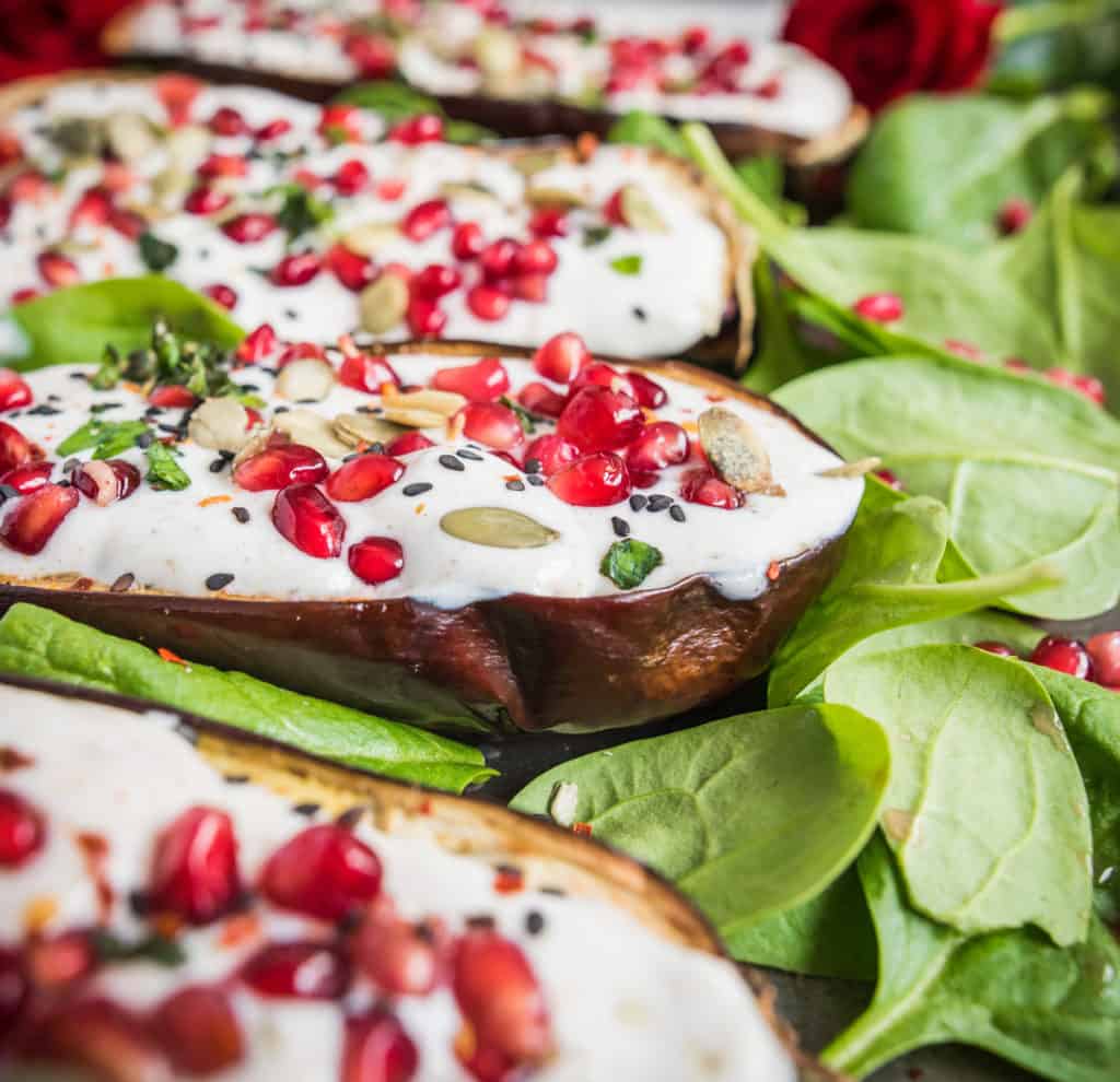 Spicy roasted aubergine recipe bursting with flavours and colours served with creamy yoghurt dressing, pomegranate and sunflower seeds. Vegan & gluten free.