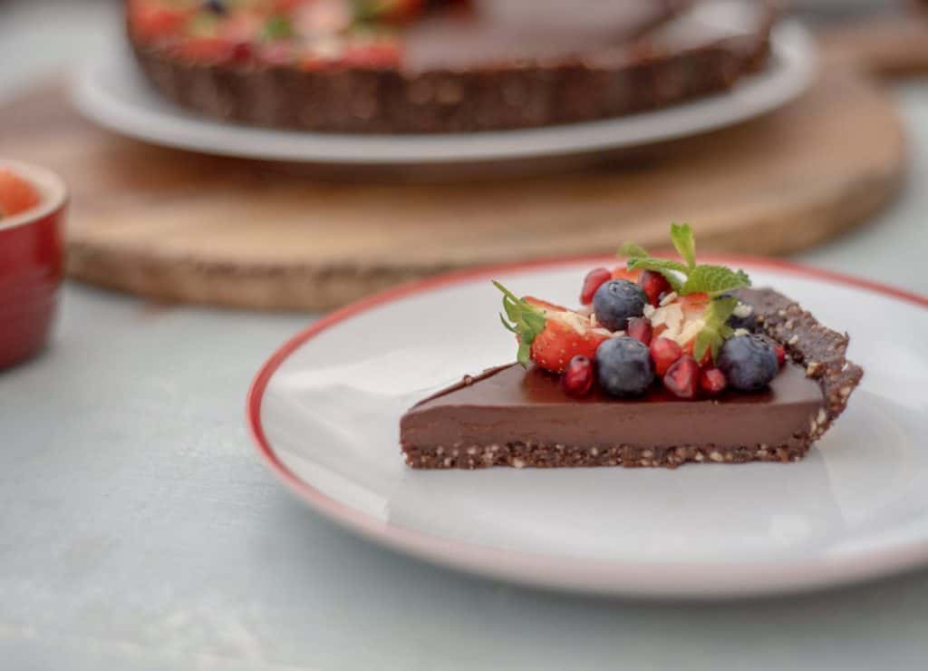 Really simple, healthy chocolate tart recipe to whip up for a last minute post-dinner treat or lazy Sunday cooking session. The rich, glossy chocolate ganache and gorgeous berries just bring it all together in the sweetest, freshest way! It's just pure, silky, smooth chocolate decadence #vegan #dairyfree #glutenfree #cleaneating