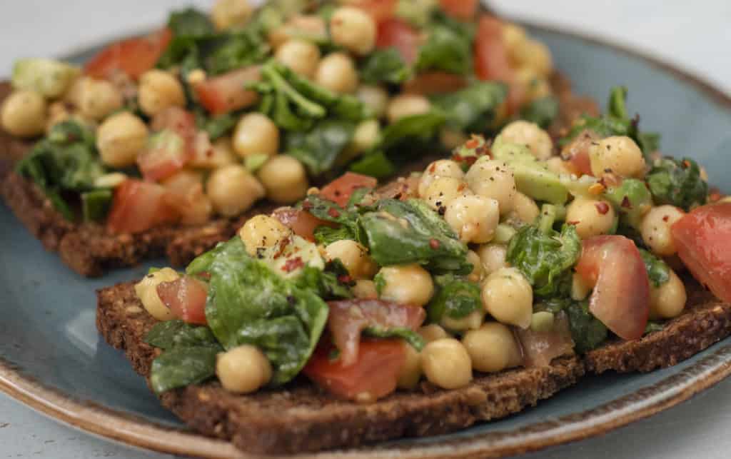 Healthy and super delicious Avocado Chickpea Tomato Toast recipe which is an easy fully plant based/vegan breakfast, snack or lunch for days when you can't be bothered to cook or it's too hot outside #vegan #avocadotoast #vegetarian #dairyfree
