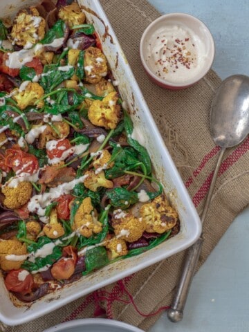 Absolutely delicious one-pot healthy cauliflower bake recipe served with lush tahini and yoghurt dressing. Super-satisfying while vegan, gluten & grain free!#veganrecipes #glutenfree #dairyfree #cauliflowerbake #healthyrecipes #cleanrecipes #cleaneating #easyrecipes