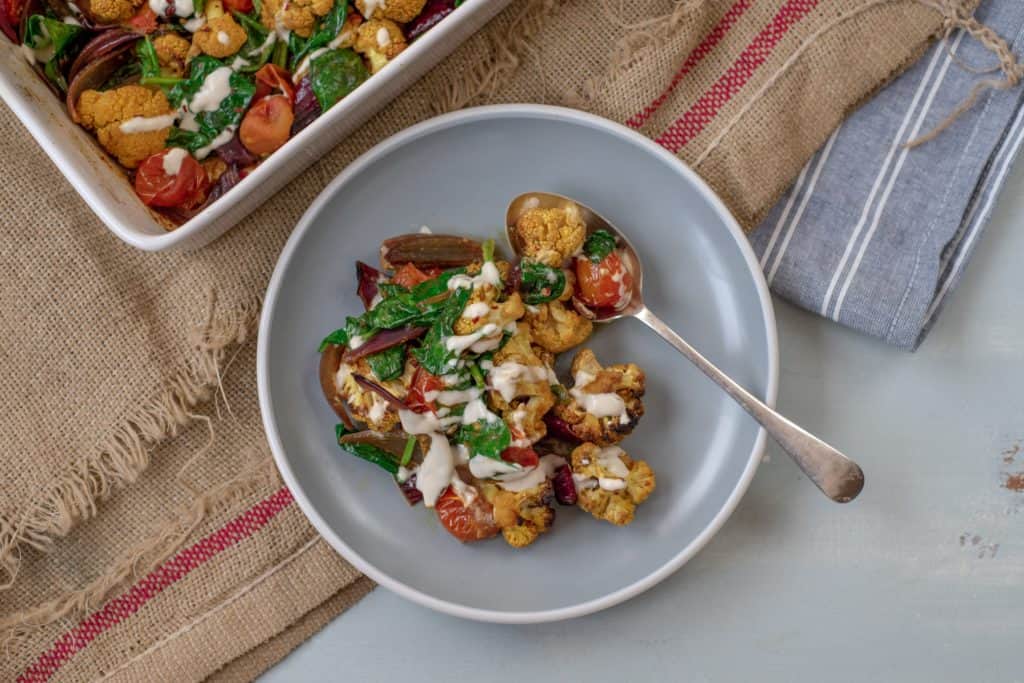 Absolutely delicious one-pot healthy cauliflower bake recipe served with lush tahini and yoghurt dressing. Super-satisfying while vegan, gluten & grain free!#veganrecipes #glutenfree #dairyfree #cauliflowerbake #healthyrecipes #cleanrecipes #cleaneating #easyrecipes 