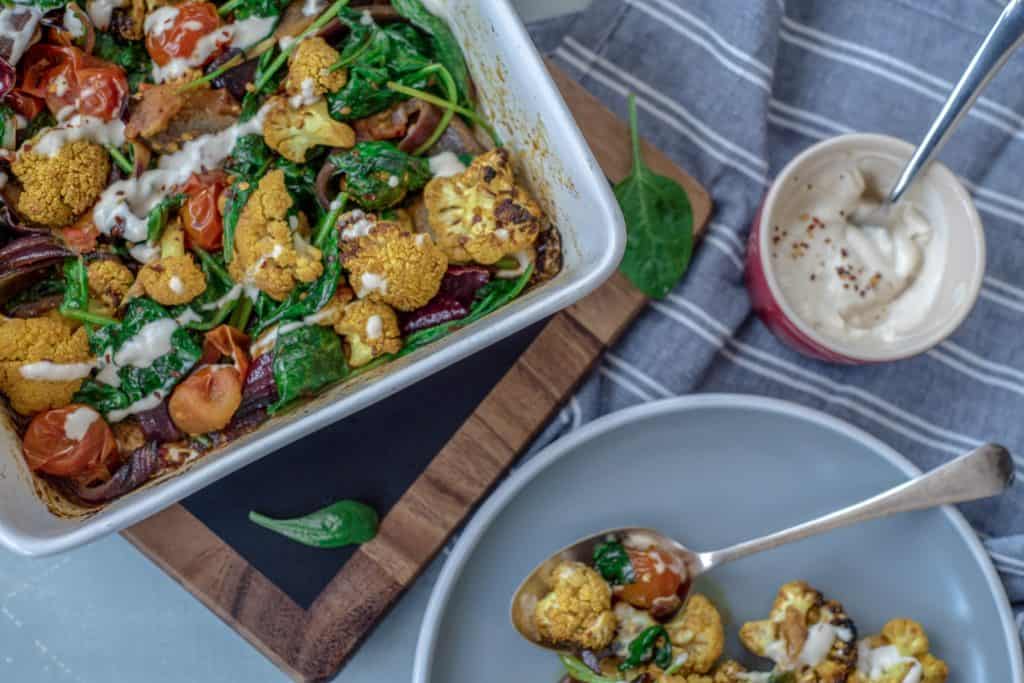 Absolutely delicious one-pot healthy cauliflower bake recipe served with lush tahini and yoghurt dressing. Super-satisfying while vegan, gluten & grain free!#veganrecipes #glutenfree #dairyfree #cauliflowerbake #healthyrecipes #cleanrecipes #cleaneating #easyrecipes 