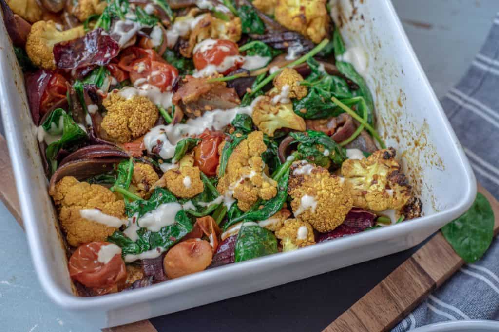 Absolutely delicious one-pot healthy cauliflower bake recipe served with lush tahini and yoghurt dressing. Super-satisfying while vegan, gluten & grain free!#veganrecipes #glutenfree #dairyfree #cauliflowerbake #healthyrecipes #cleanrecipes #cleaneating #easyrecipes 